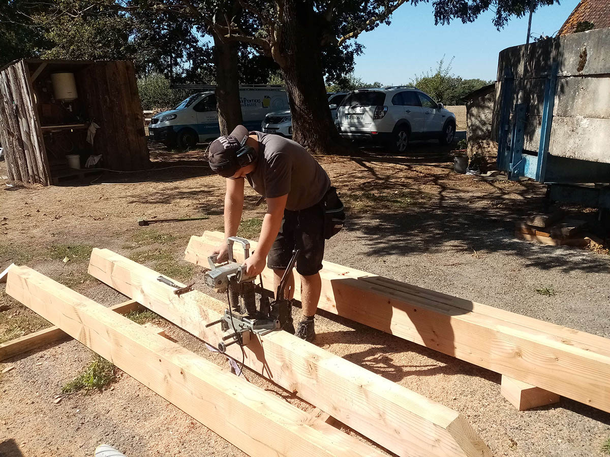 Ajustement d’une pièce de bois sur le chantier
