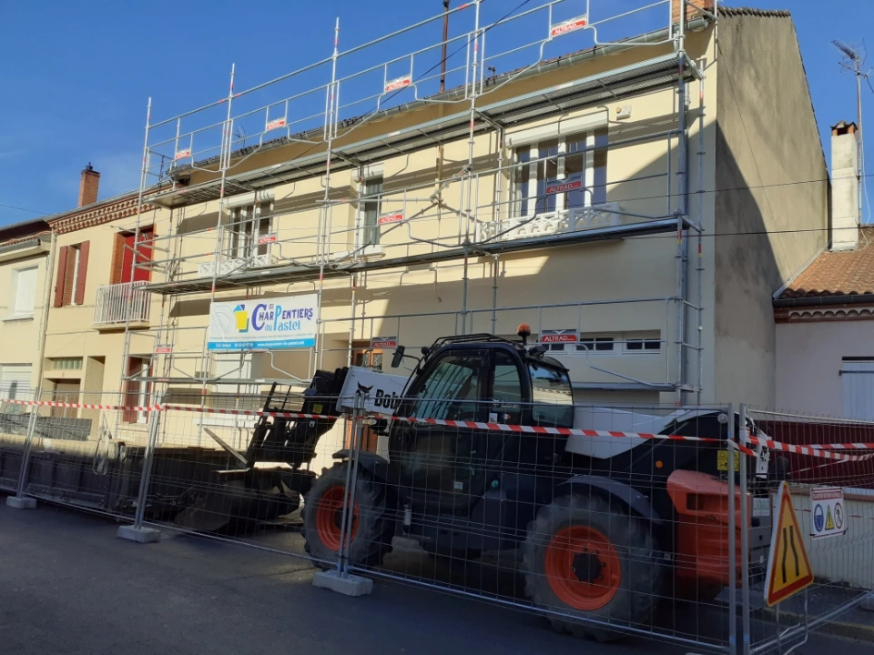 Échafaudage et matériel de levage devant la maison