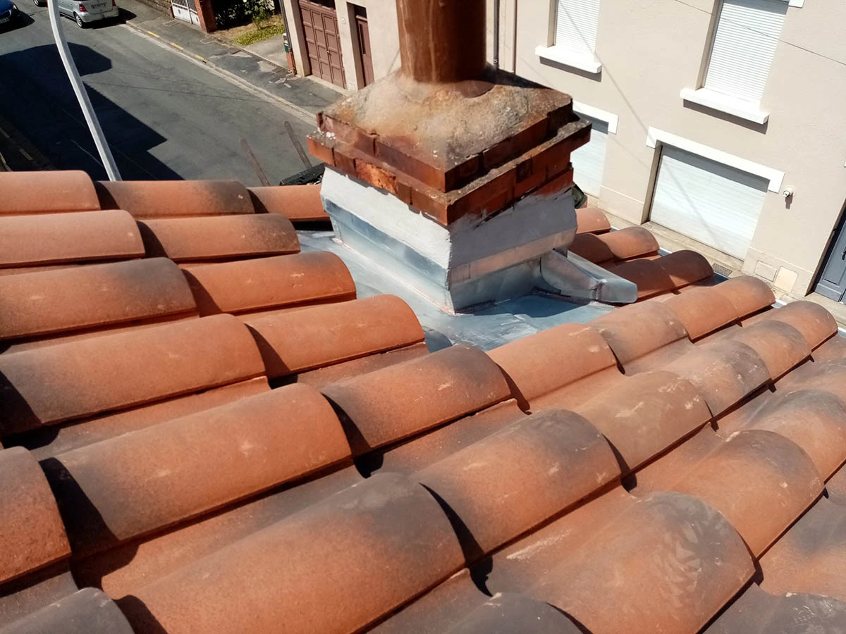 Raccord en zinc autour de la cheminée sur la toiture rénovée