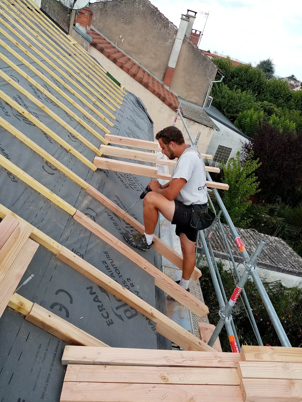Pose des liteaux par un couvreur sur la toiture