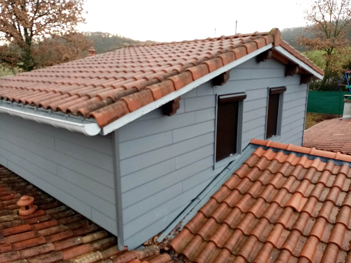 Habillage de façade en zinc sous une toiture en tuiles