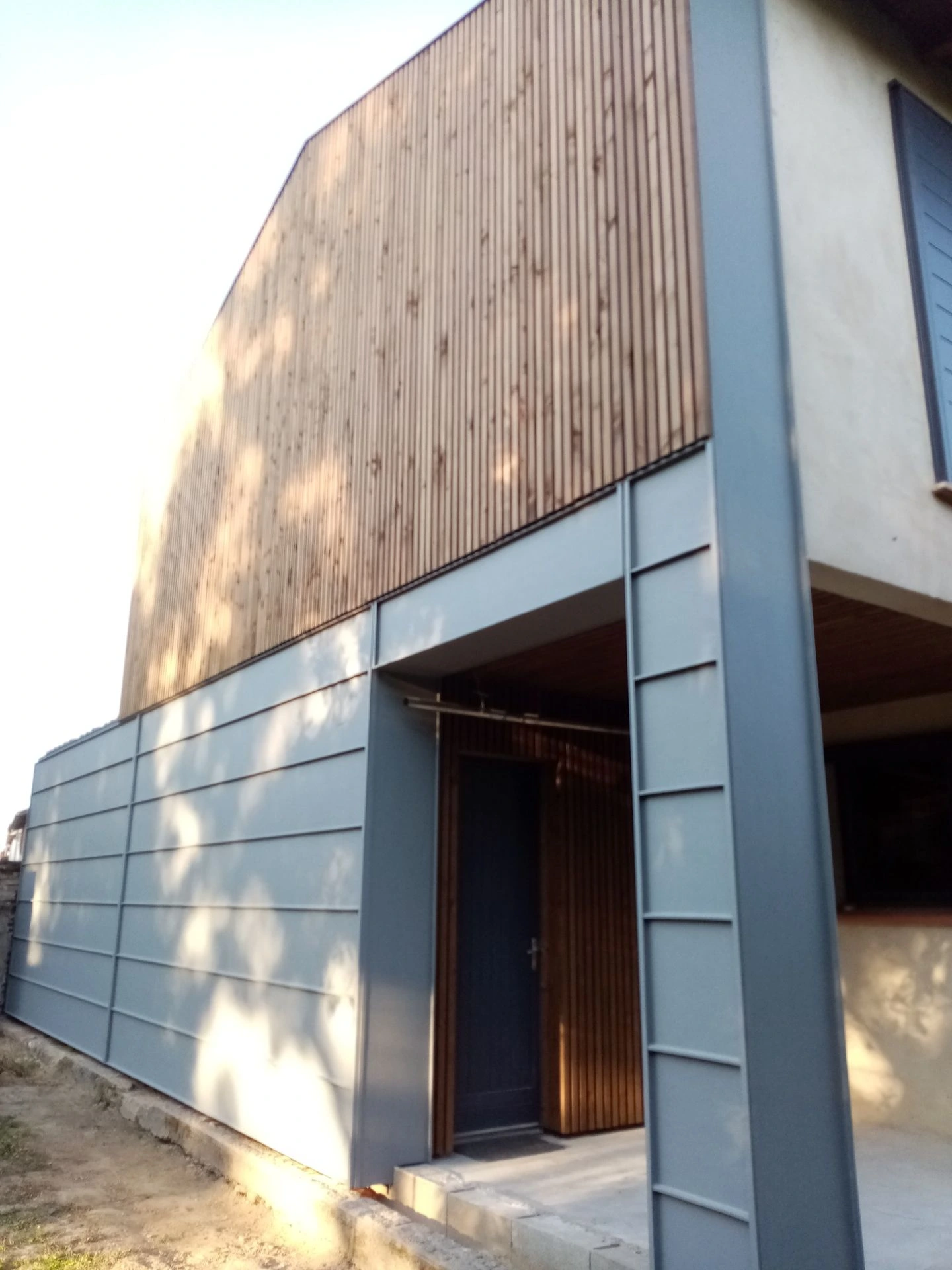 Bardage en bois terminé au-dessus de l’entrée