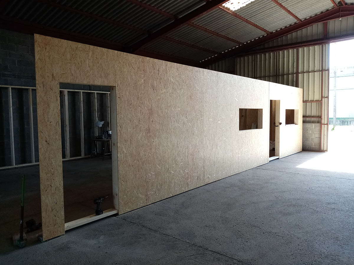 Façade des bureaux en panneaux de bois, avec ouvertures